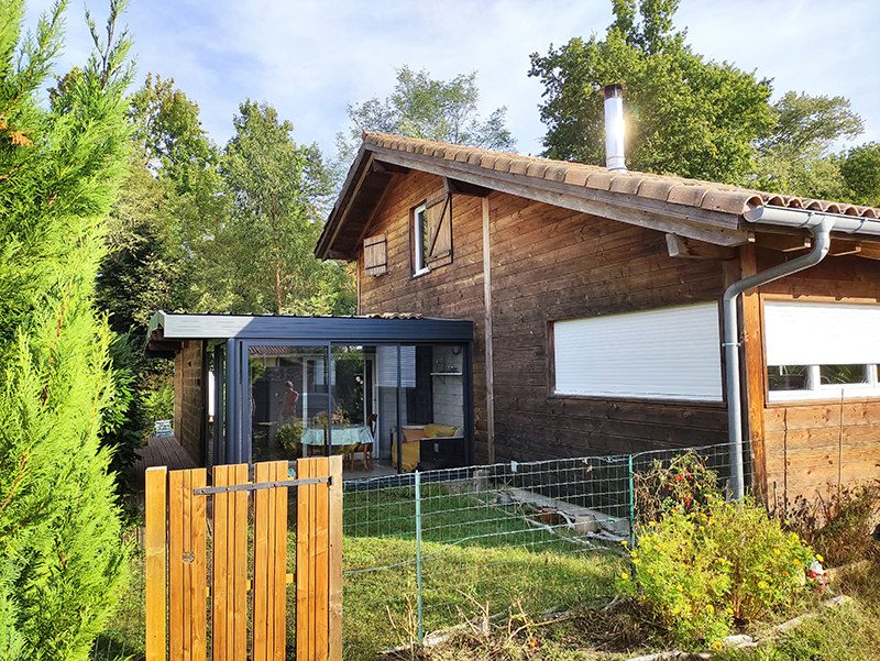 Photographie 2 de la maison en bardage bois avec sa véranda qui a servie de modèle à la réalisation du dessin personnalisé.